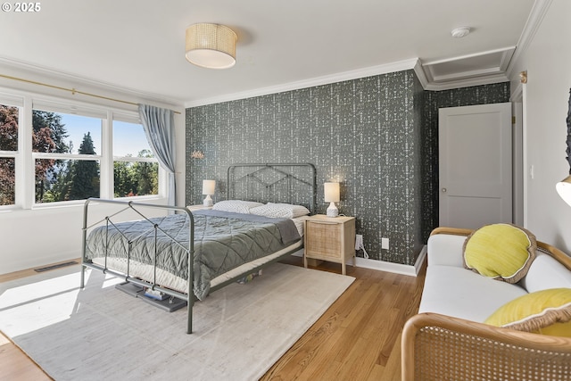 bedroom with ornamental molding, wallpapered walls, wood finished floors, and baseboards