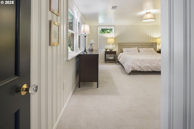 bedroom featuring light carpet and baseboards