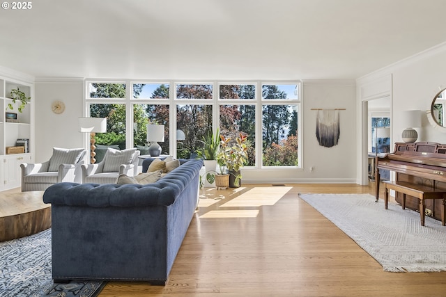 living room featuring ornamental molding, wood finished floors, and baseboards