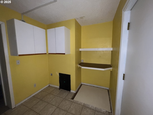 tiled spare room featuring a textured ceiling