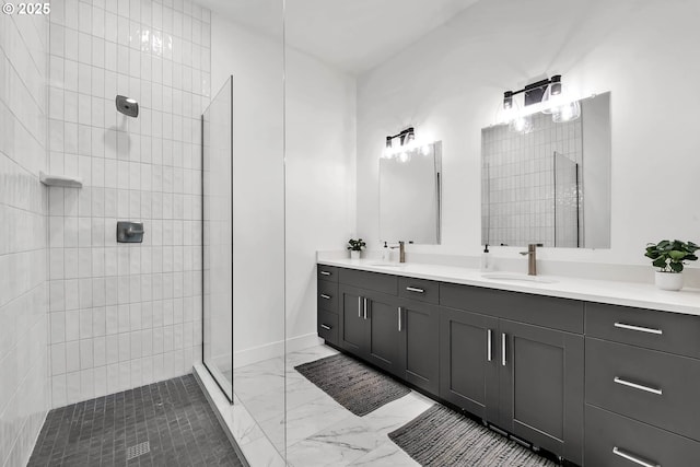 bathroom with a tile shower and vanity