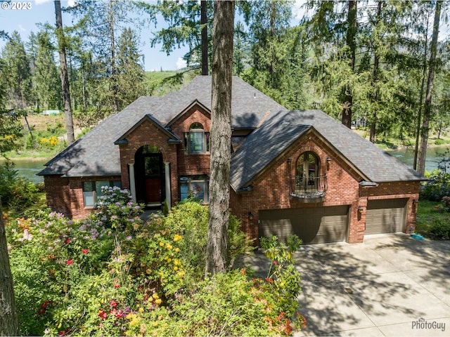 46769 Goodpasture Rd, Vida, OR 97488 - traditional home with a garage, brick siding, driveway, and a shingled roof