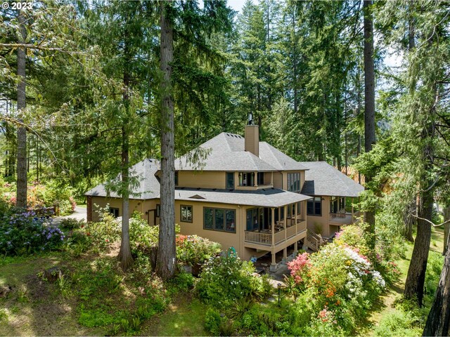 46769 Goodpasture Rd, Vida, OR 97488 - back of house featuring stairs, roof with shingles, a forest view, and a chimney
