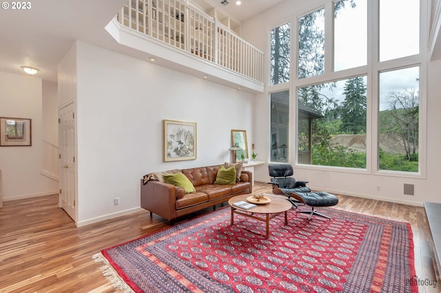 46769 Goodpasture Rd, Vida, OR 97488 - living room featuring wood finished floors, visible vents, a towering ceiling, and baseboards