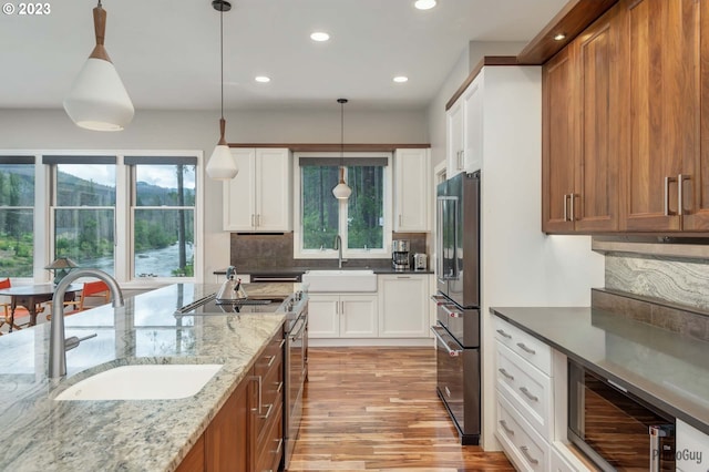46769 Goodpasture Rd, Vida, OR 97488 - kitchen featuring a healthy amount of sunlight, light wood finished floors, a sink, and appliances with stainless steel finishes