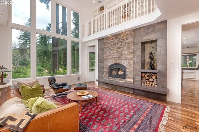46769 Goodpasture Rd, Vida, OR 97488 - living room featuring plenty of natural light, a towering ceiling, a stone fireplace, and wood finished floors