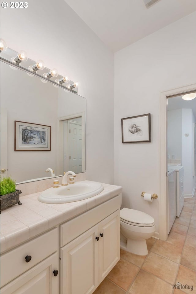 46769 Goodpasture Rd, Vida, OR 97488 - bathroom featuring tile patterned flooring, vanity, washer and clothes dryer, and toilet