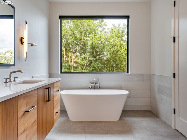 522 NE Province Dr, Camas, WA 98607 - bathroom with vanity, tile walls, a freestanding bath, healthy amount of natural light, and tile patterned floors