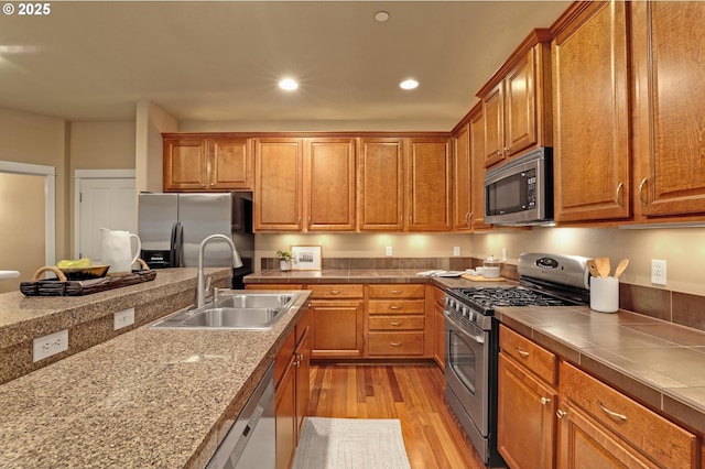 kitchen featuring appliances with stainless steel finishes, sink, and light wood-type flooring