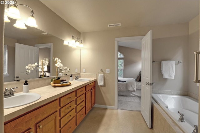 bathroom featuring vanity and tiled bath