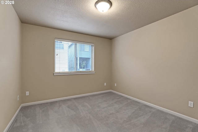 carpeted spare room with a textured ceiling