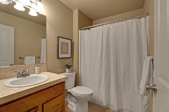 bathroom with vanity, toilet, and decorative backsplash