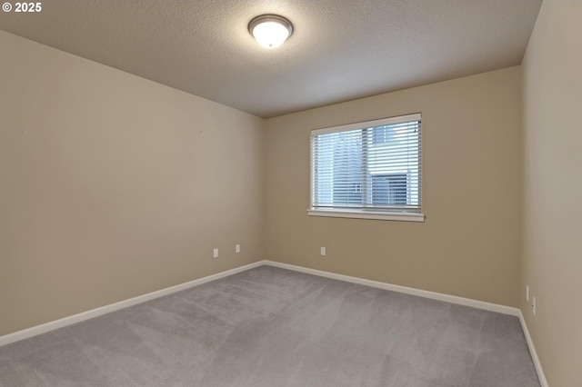 carpeted empty room featuring a textured ceiling