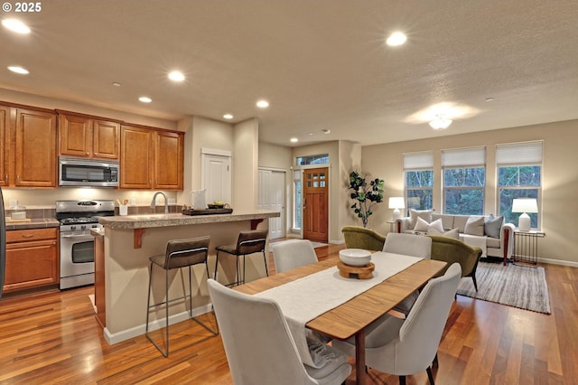 dining space featuring light hardwood / wood-style floors and a textured ceiling