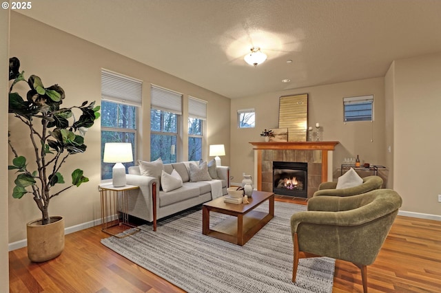 living room with wood-type flooring and a tile fireplace