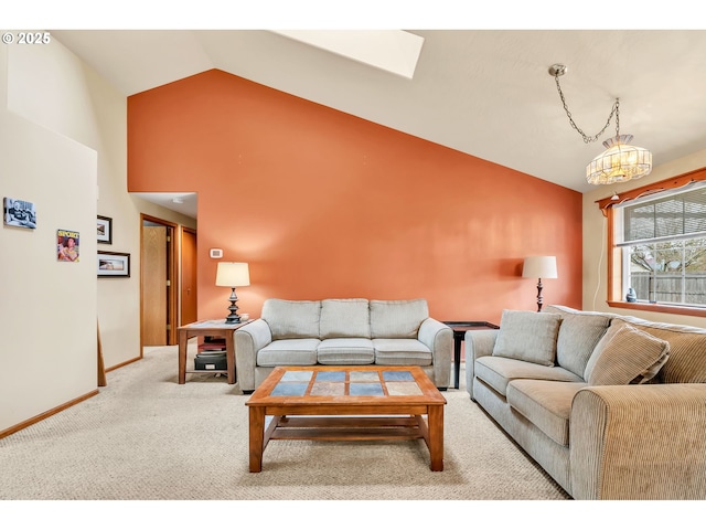 living room featuring carpet floors, high vaulted ceiling, a chandelier, baseboards, and a skylight