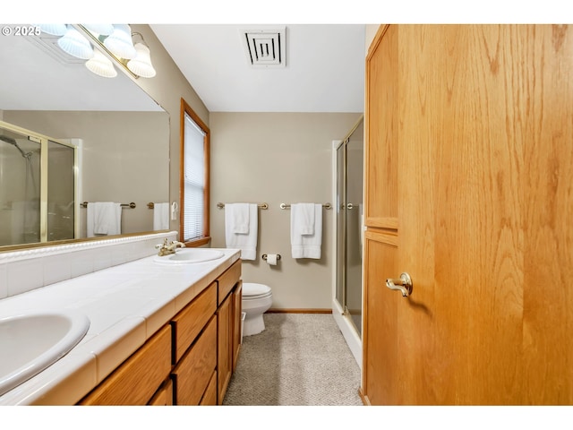 full bathroom with toilet, visible vents, a sink, and a stall shower