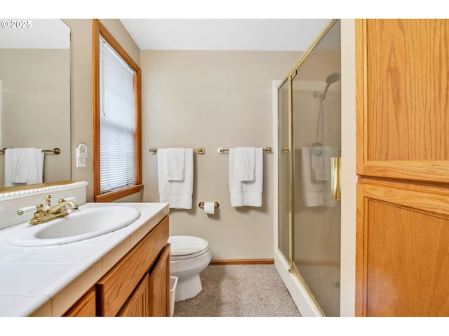 bathroom with toilet, baseboards, a shower stall, and vanity