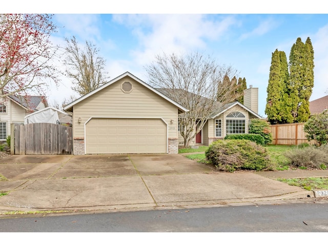 single story home with concrete driveway, brick siding, an attached garage, and fence