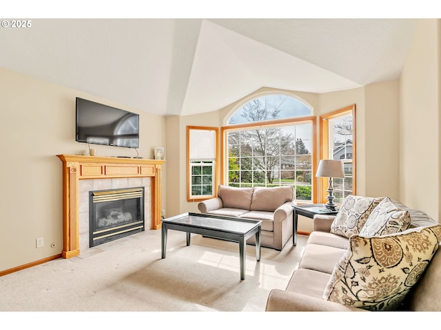 living area featuring baseboards, light carpet, lofted ceiling, and a tile fireplace