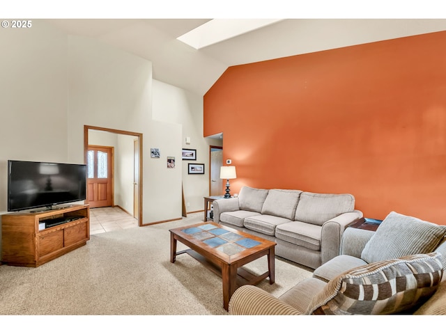 living area with baseboards, a skylight, light carpet, and high vaulted ceiling