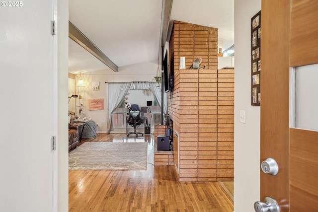 foyer entrance with beamed ceiling and wood finished floors