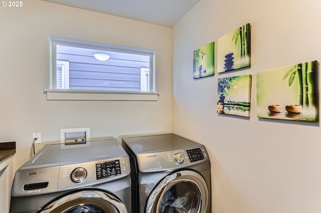 clothes washing area with washing machine and dryer, a healthy amount of sunlight, and laundry area