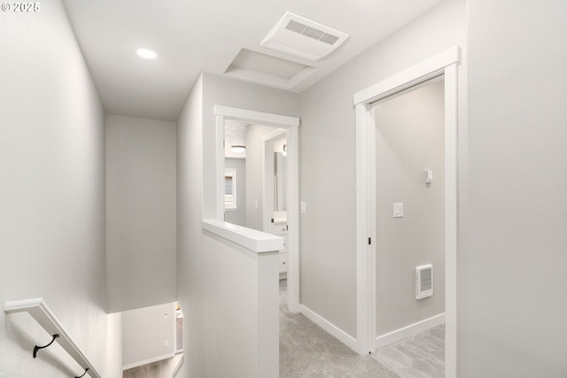 hall with light colored carpet, an upstairs landing, visible vents, and baseboards