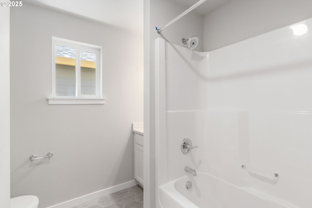 bathroom featuring baseboards, toilet, tile patterned floors, bathtub / shower combination, and vanity