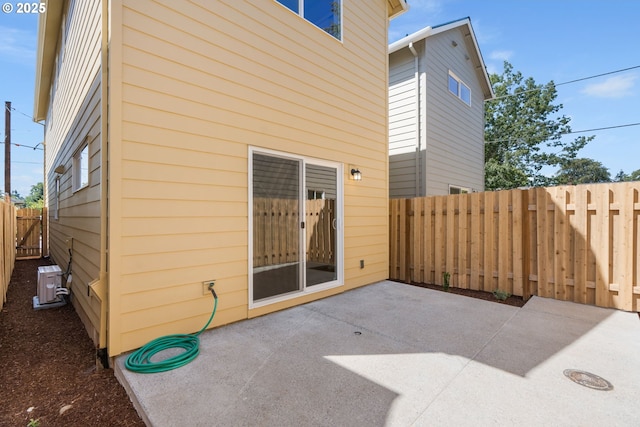 exterior space featuring cooling unit, a fenced backyard, and a patio