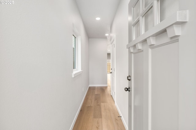 hall featuring recessed lighting, light wood-style flooring, and baseboards