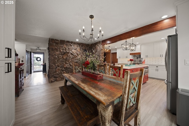 dining area with recessed lighting, a notable chandelier, and light wood finished floors