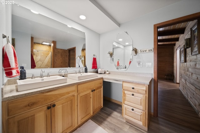 bathroom with wood finished floors, wooden walls, a shower, and a sink