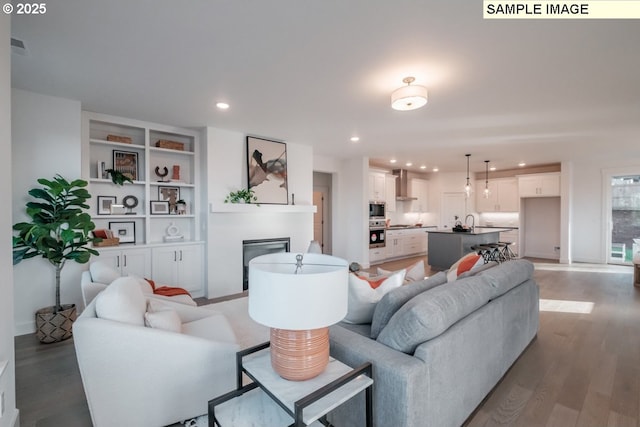 living room with built in features and light wood-type flooring