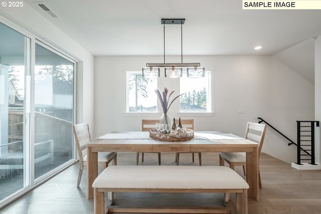 dining room featuring a wealth of natural light, light hardwood / wood-style flooring, and lofted ceiling