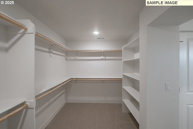 spacious closet featuring dark carpet