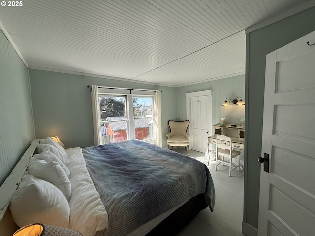 bedroom with crown molding and wood finished floors