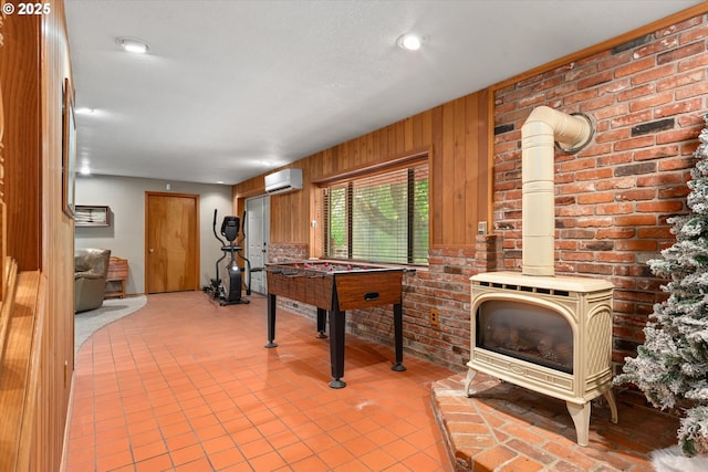 62436 Mink Ln, Summerville, OR 97876 - game room with a wall unit AC, a wood stove, and tile patterned flooring