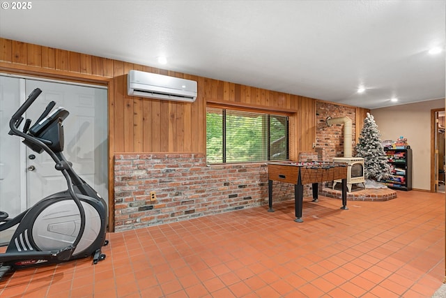 62436 Mink Ln, Summerville, OR 97876 - exercise area featuring a wall mounted AC, brick wall, a wood stove, wooden walls, and recessed lighting