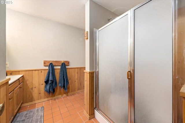 62436 Mink Ln, Summerville, OR 97876 - bathroom with vanity, a wainscoted wall, a shower stall, tile patterned flooring, and wooden walls