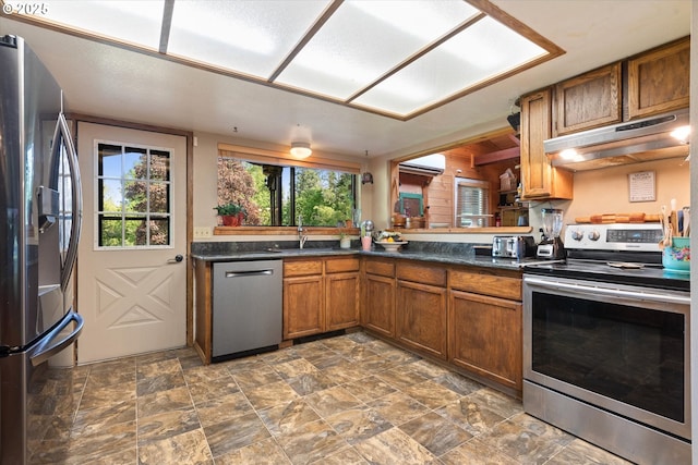 62436 Mink Ln, Summerville, OR 97876 - kitchen featuring appliances with stainless steel finishes, under cabinet range hood, a sink, dark countertops, and brown cabinets