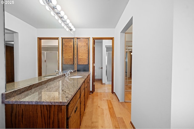 765 5th Ave Unit 5, Hammond, OR 97121 - bathroom with wood finished floors, double vanity, and a shower with shower door