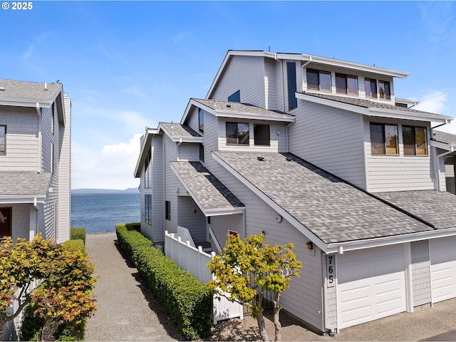 765 5th Ave Unit 5, Hammond, OR 97121 - view of side of property featuring a shingled roof, a water view, and an attached garage