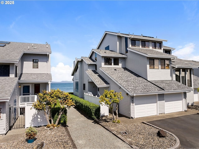 765 5th Ave Unit 5, Hammond, OR 97121 - view of home's exterior with driveway, a garage, roof with shingles, and a water view