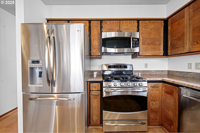 765 5th Ave Unit 5, Hammond, OR 97121 - kitchen featuring stainless steel appliances, brown cabinets, and light wood-type flooring