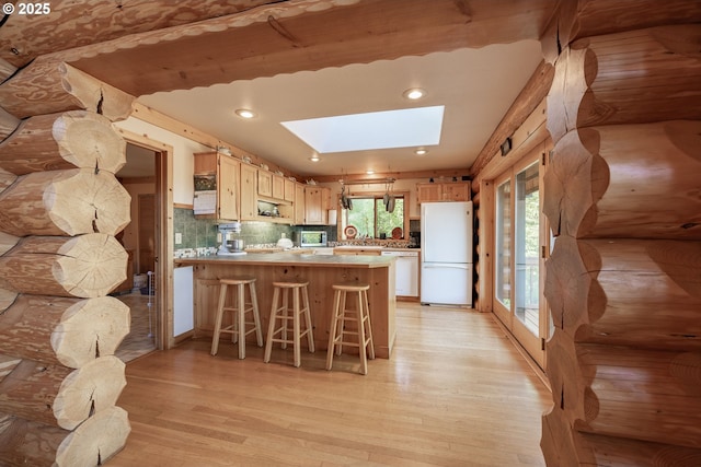35919 NE 25th Cir, Washougal, WA 98671 - kitchen featuring white appliances, a skylight, light wood-type flooring, light brown cabinets, and a peninsula