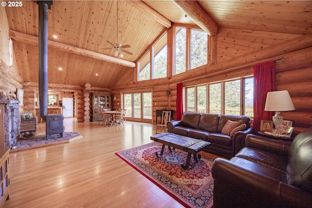 35919 NE 25th Cir, Washougal, WA 98671 - living area featuring log walls, high vaulted ceiling, wooden ceiling with exposed beams, a wood stove, and wood finished floors