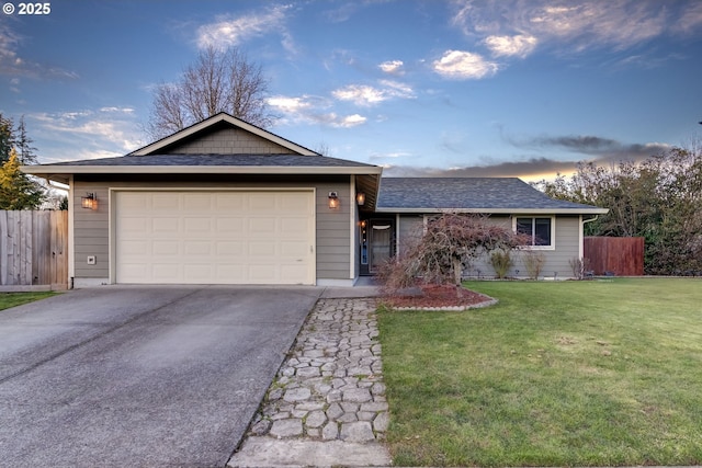 ranch-style house with a garage and a yard