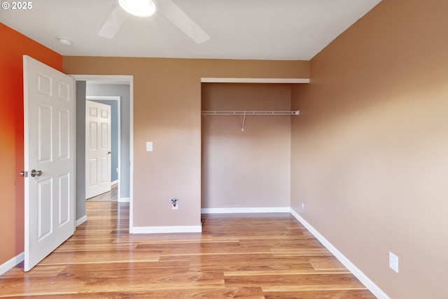 unfurnished bedroom featuring hardwood / wood-style floors, ceiling fan, and a closet