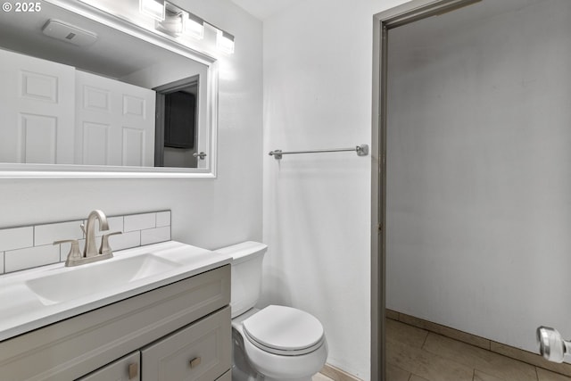 bathroom with decorative backsplash, vanity, tile patterned floors, and toilet